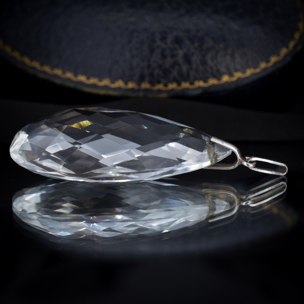 A large faceted pear-shaped clear rock crystal drop pendant featuring a sterling silver mounting loop. View IV