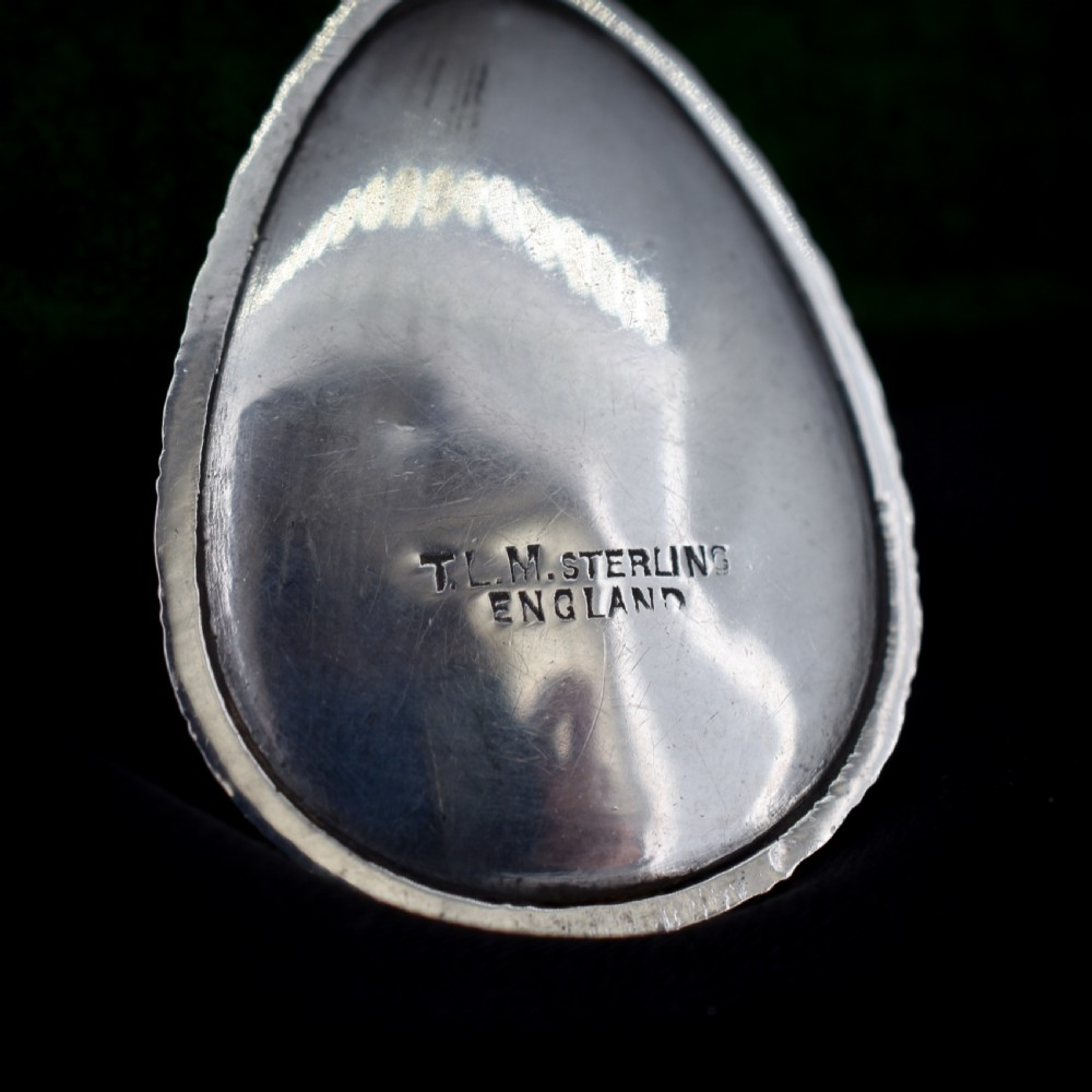 An Art Deco teardrop-shaped sterling silver pendant featuring a reverse-painted tropical palm scene over an iridescent blue butterfly wing. View XI