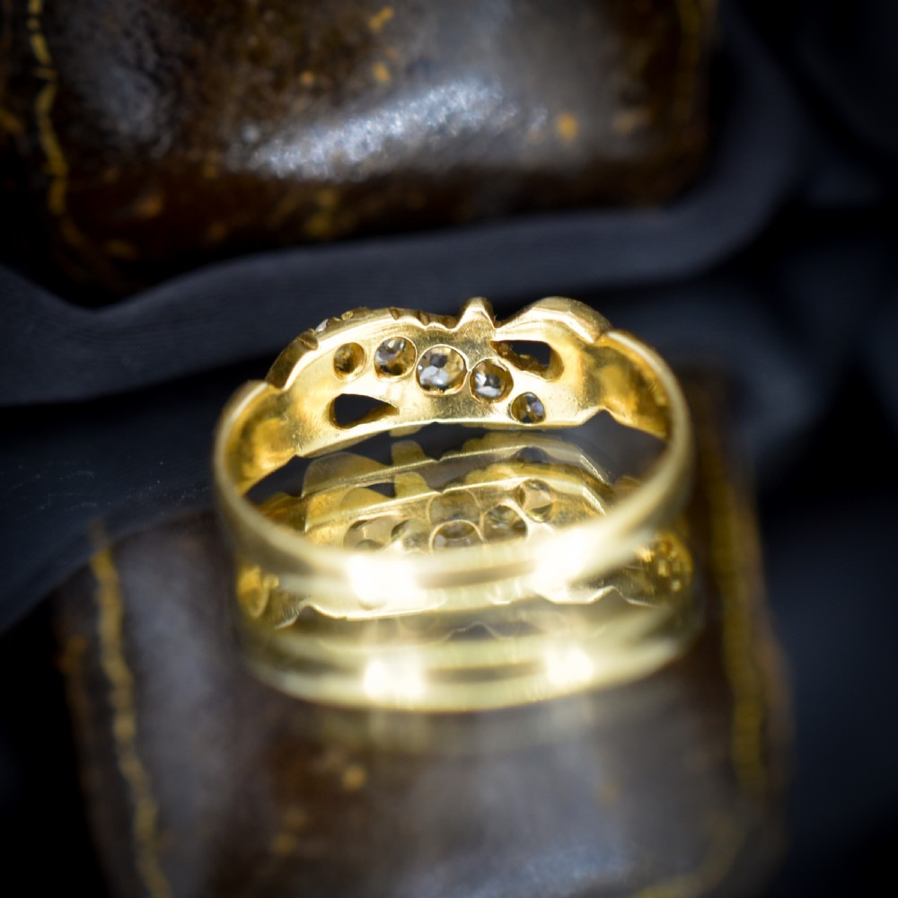 An 18ct yellow gold ring set with five graduated old-cut diamonds across a carved scrollwork band. View IX