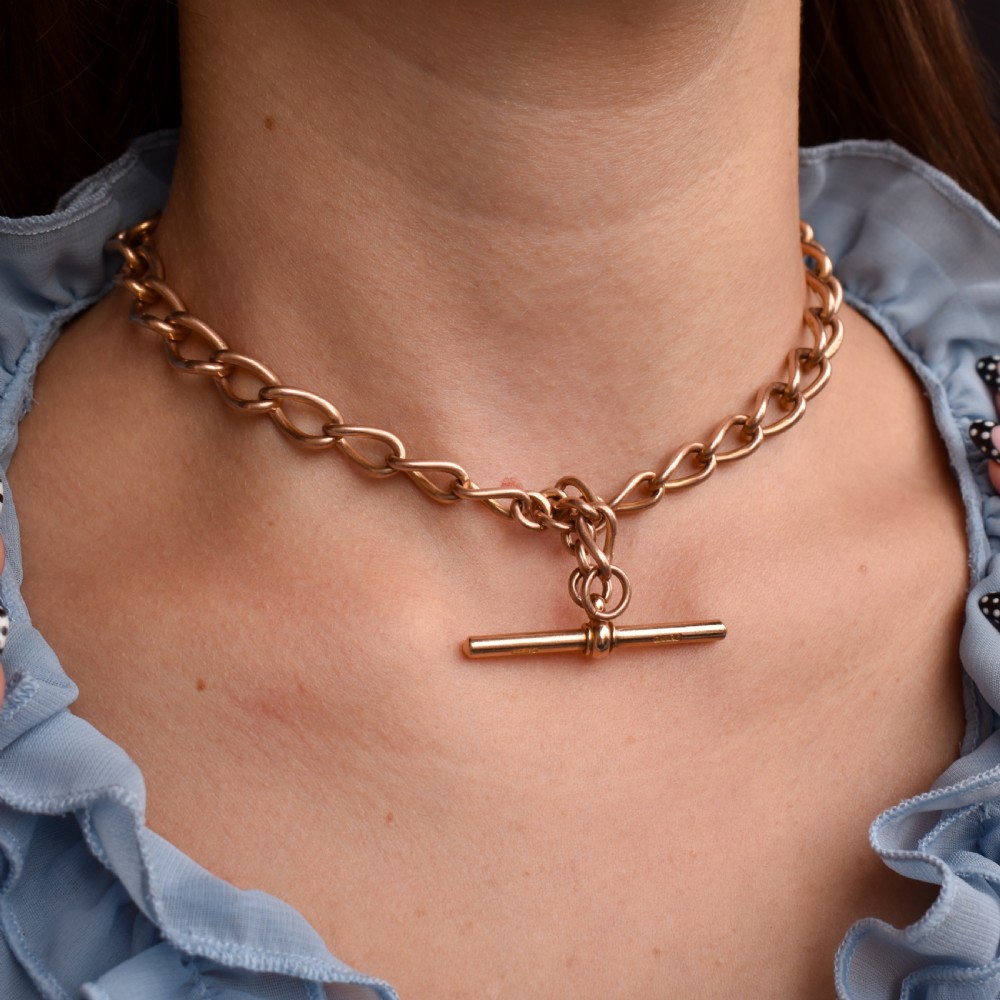 An antique 9ct gold Albert watch chain featuring oval links, a central T-bar, and double dog clip clasps. View IX