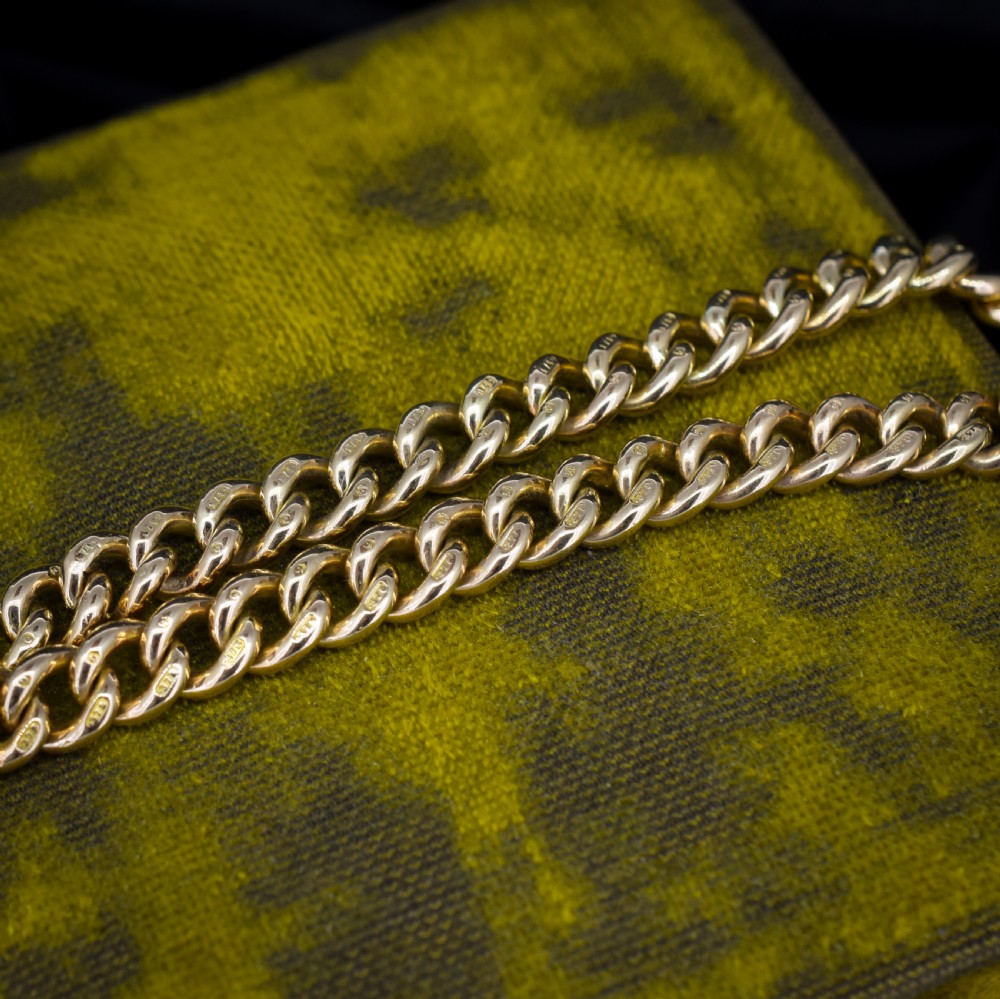 An antique 9ct yellow gold curb link chain bracelet fitted with a heart-shaped padlock clasp and an attached safety chain. View VIII