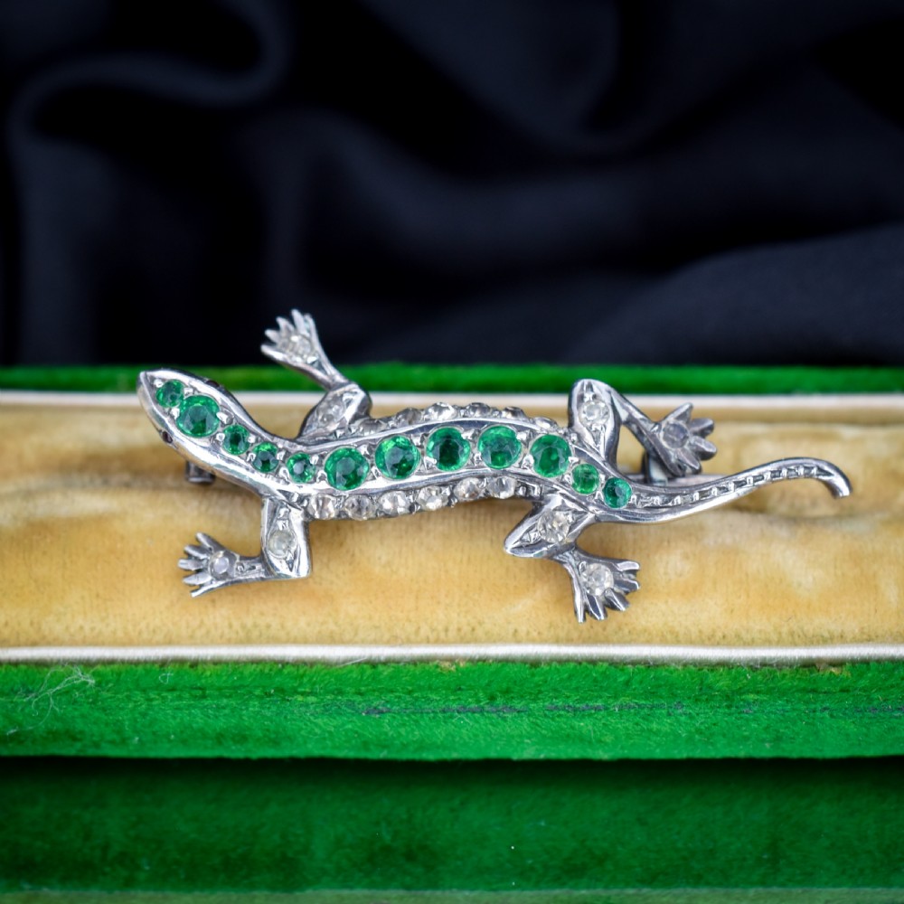 A Victorian silver lizard brooch set with green and clear paste stones.