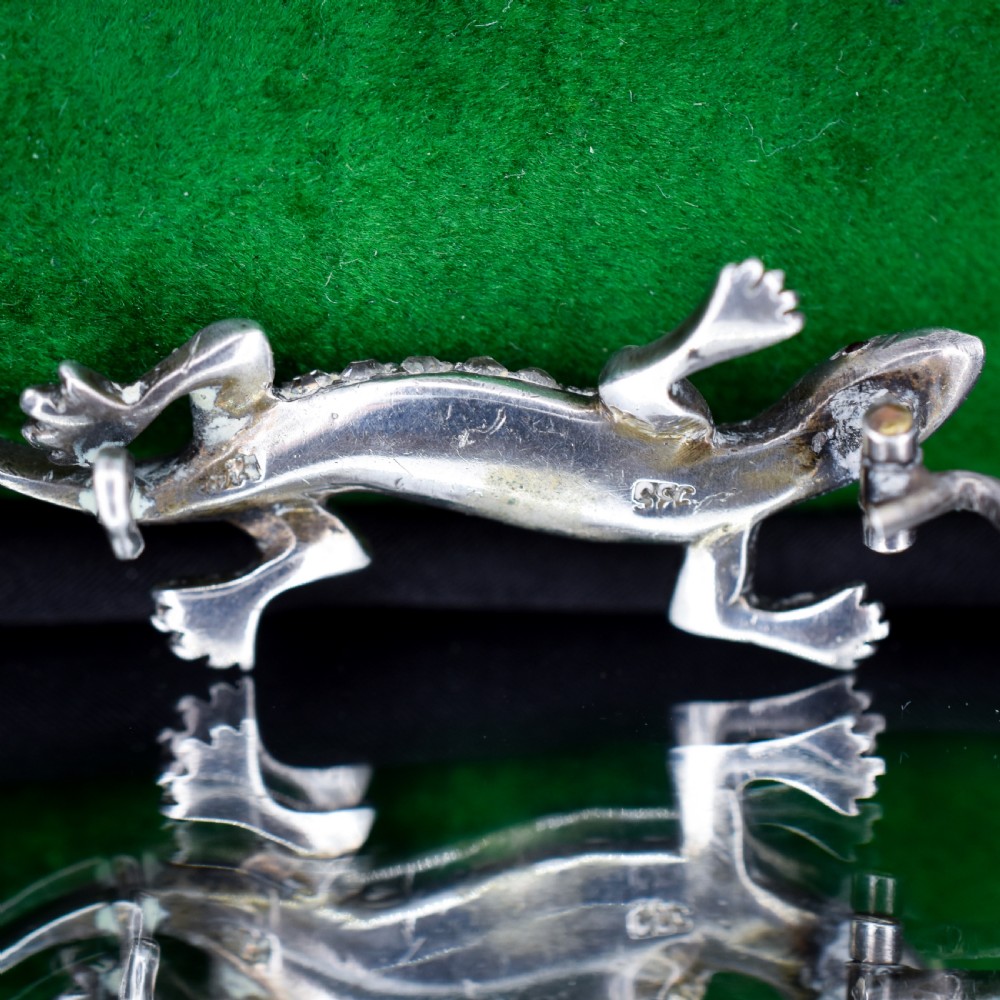 A Victorian silver lizard brooch set with green and clear paste stones. View VII