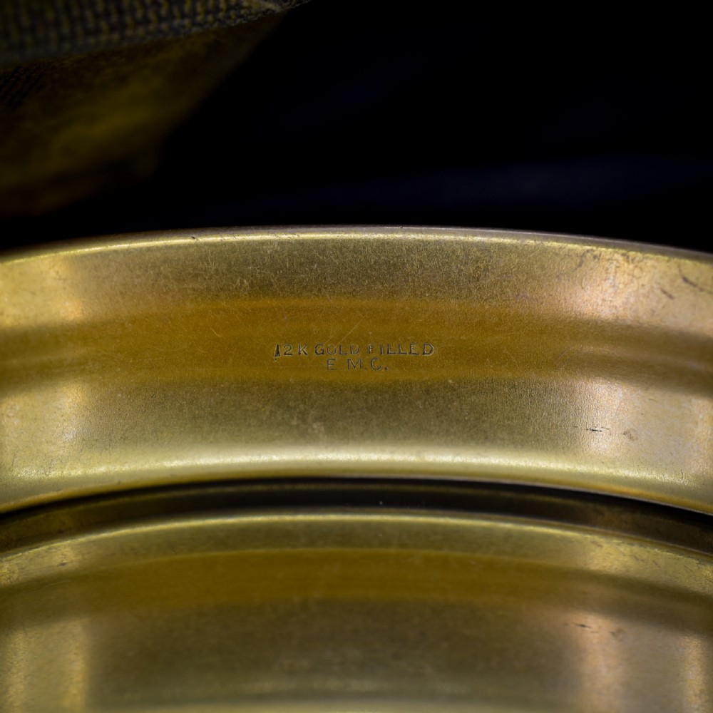 An antique gold-filled hinged bangle decorated with raised floral motifs with red and clear paste stone centres. View XII
