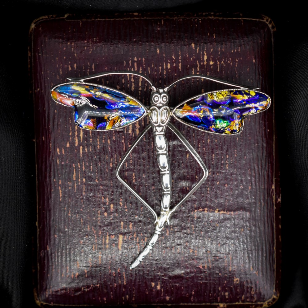 An Art Deco sterling silver dragonfly brooch featuring a stylized segmented body and iridescent blue and orange wing inserts. View III