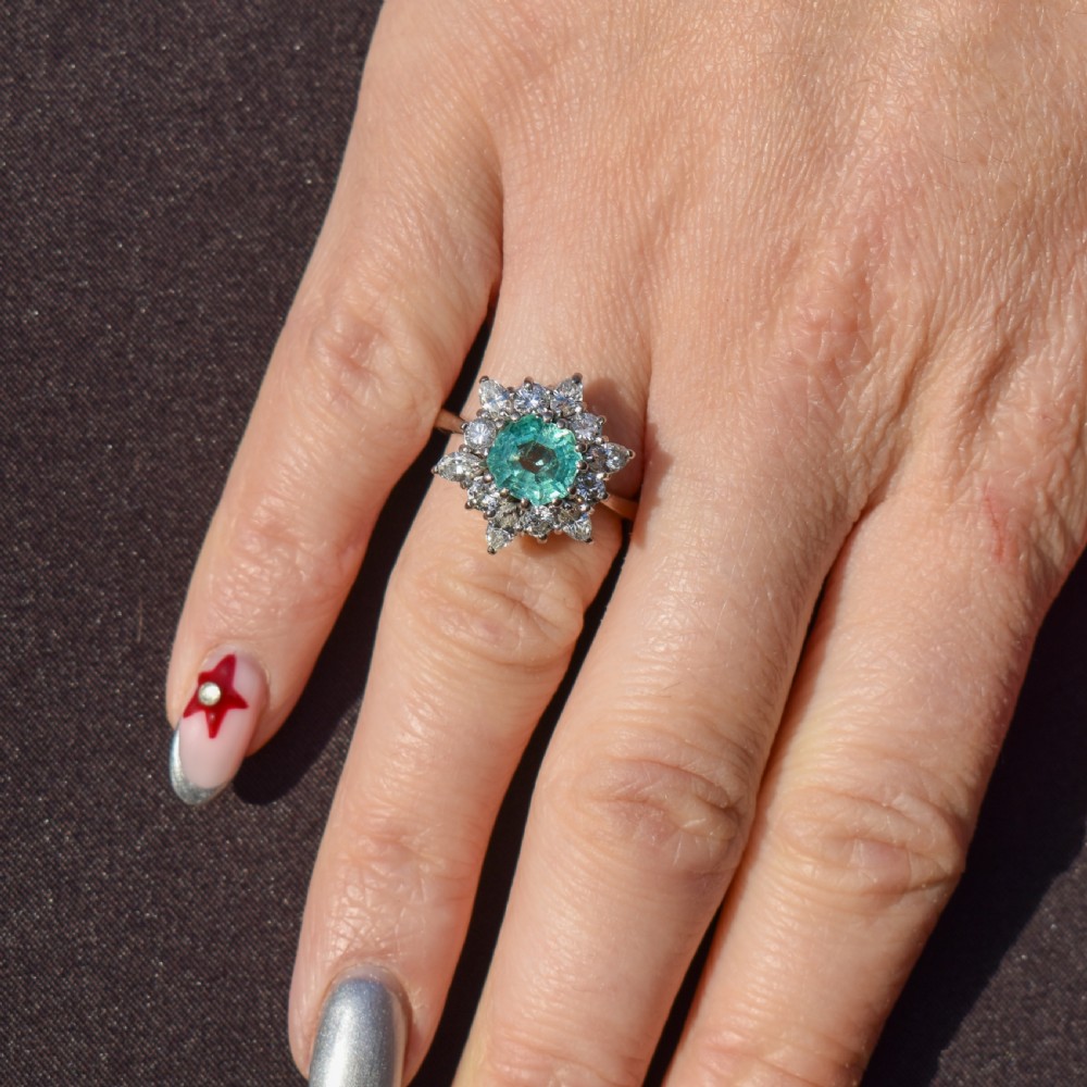 A vintage gold cluster ring featuring a central octagonal green emerald surrounded by a snowflake halo of round and marquise diamonds. View II