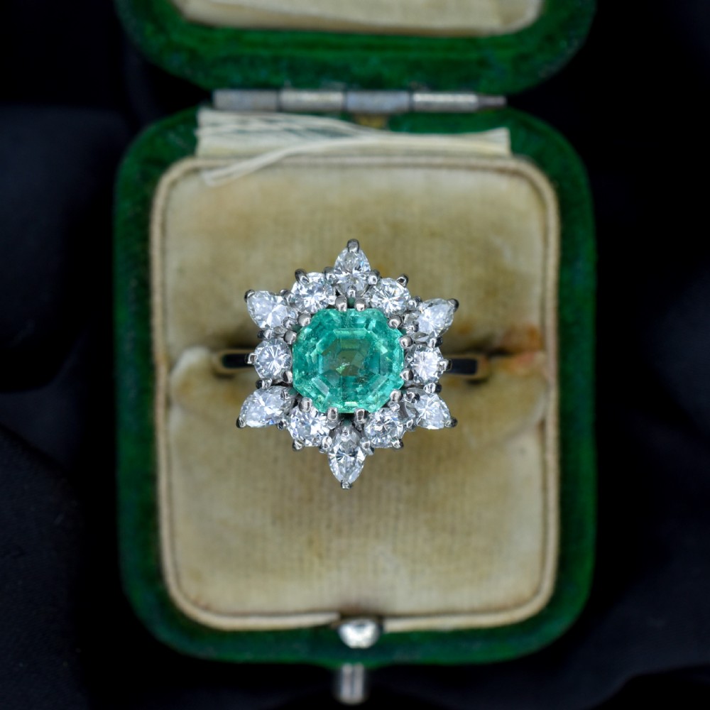 A vintage gold cluster ring featuring a central octagonal green emerald surrounded by a snowflake halo of round and marquise diamonds. View III