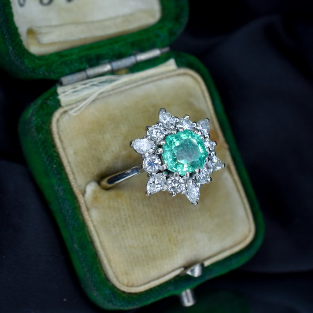 A vintage gold cluster ring featuring a central octagonal green emerald surrounded by a snowflake halo of round and marquise diamonds. View VI
