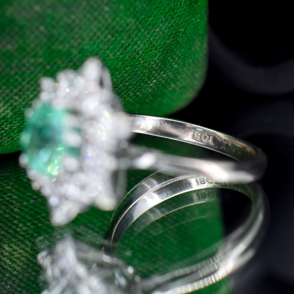 A vintage gold cluster ring featuring a central octagonal green emerald surrounded by a snowflake halo of round and marquise diamonds. View XI