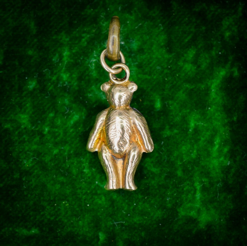 An antique 9ct gold teddy bear charm featuring a textured fur surface and a gold suspension loop. View IV