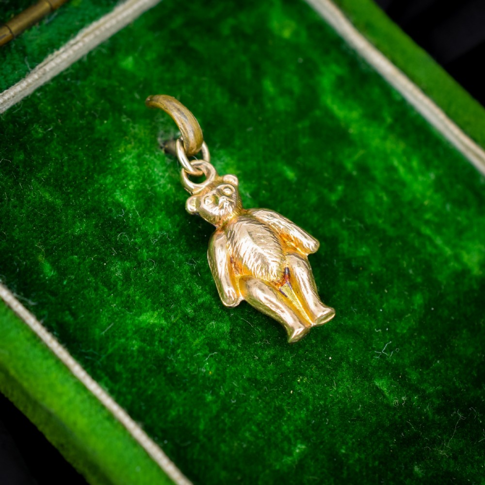 An antique 9ct gold teddy bear charm featuring a textured fur surface and a gold suspension loop. View V