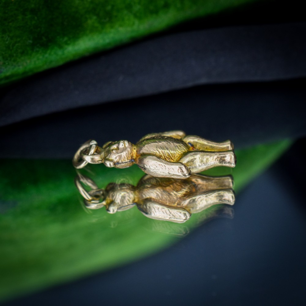 An antique 9ct gold teddy bear charm featuring a textured fur surface and a gold suspension loop. View VII
