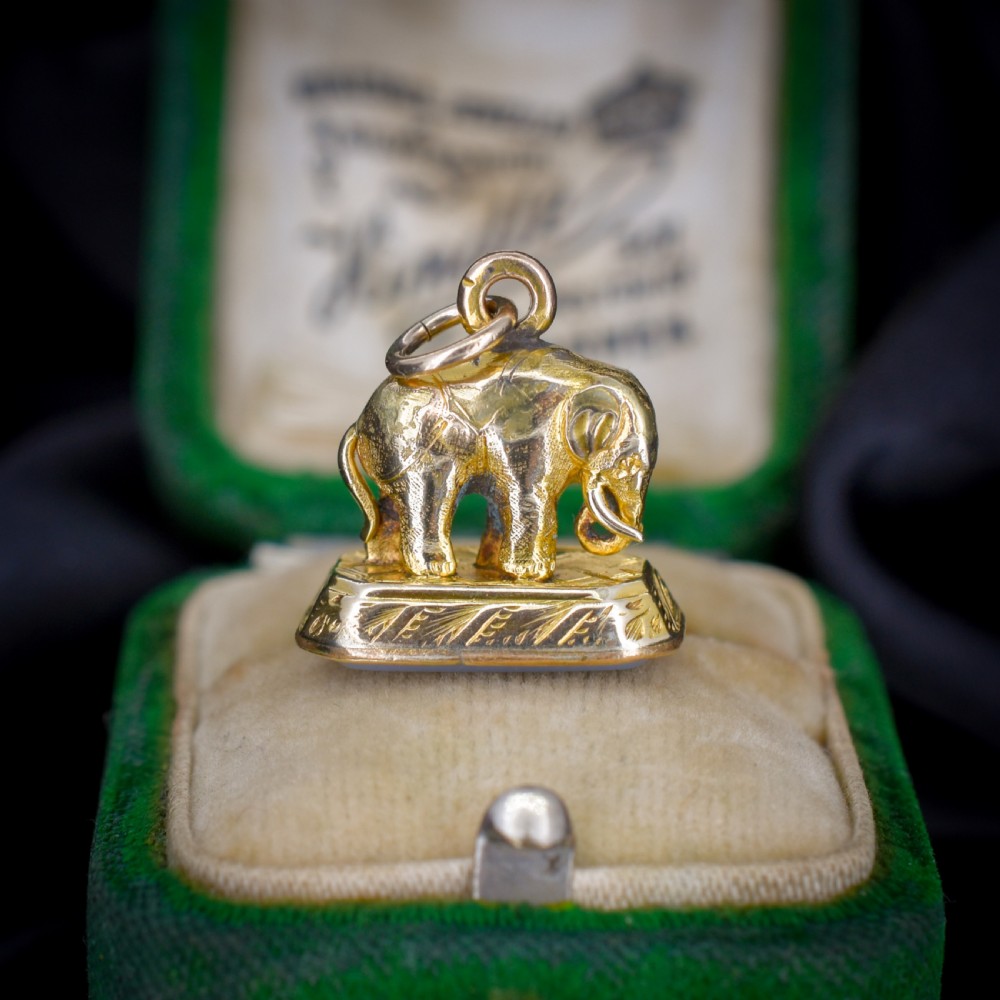 An antique gold-cased fob seal featuring a sculpted elephant figure mounted on a patterned base with a flat chalcedony matrix.