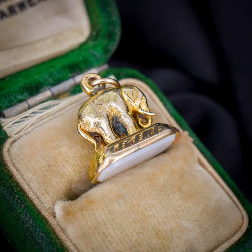 An antique gold-cased fob seal featuring a sculpted elephant figure mounted on a patterned base with a flat chalcedony matrix. View V
