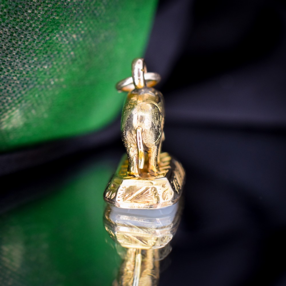 An antique gold-cased fob seal featuring a sculpted elephant figure mounted on a patterned base with a flat chalcedony matrix. View VIII