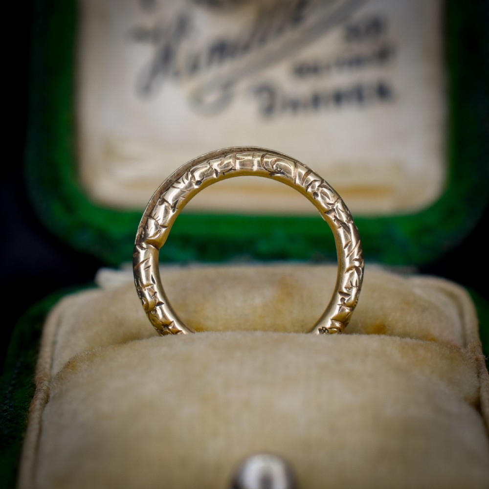 A small circular 12ct yellow gold split ring decorated with hand-engraved patterns along its outer edge. View II