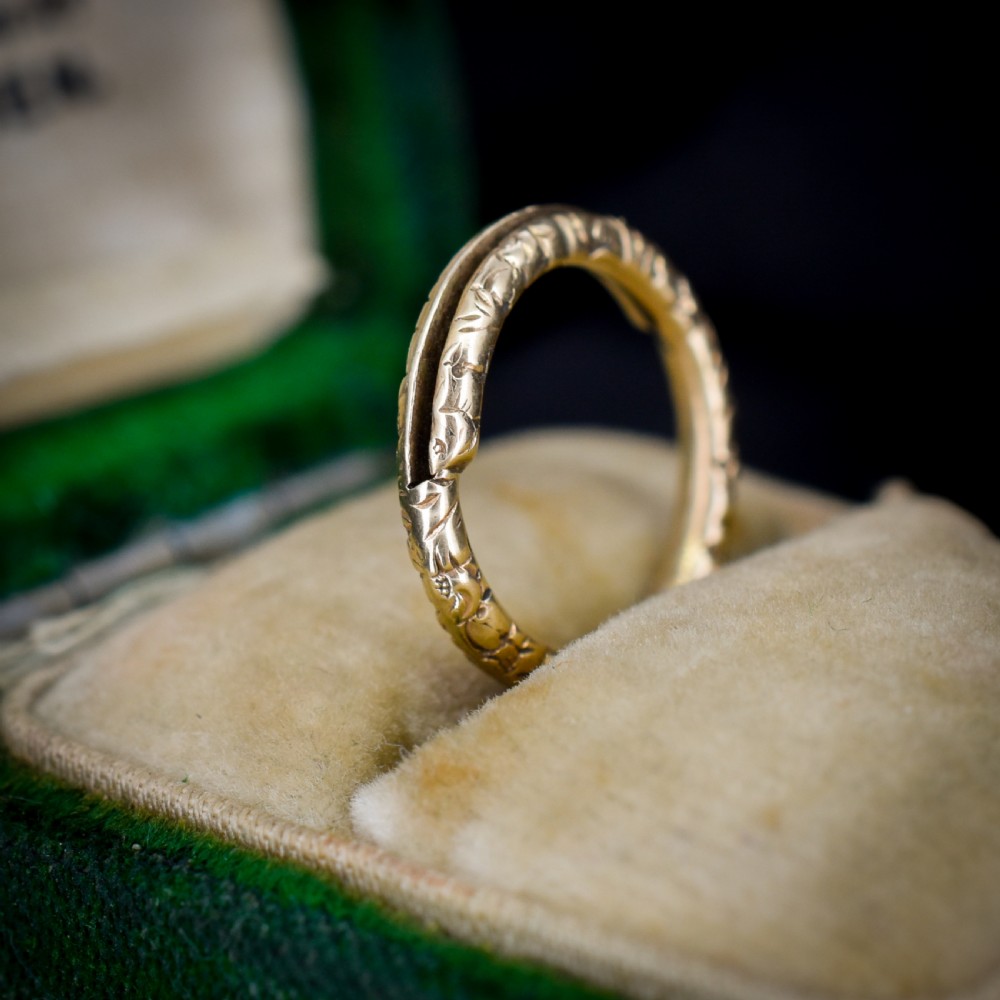 A small circular 12ct yellow gold split ring decorated with hand-engraved patterns along its outer edge. View III