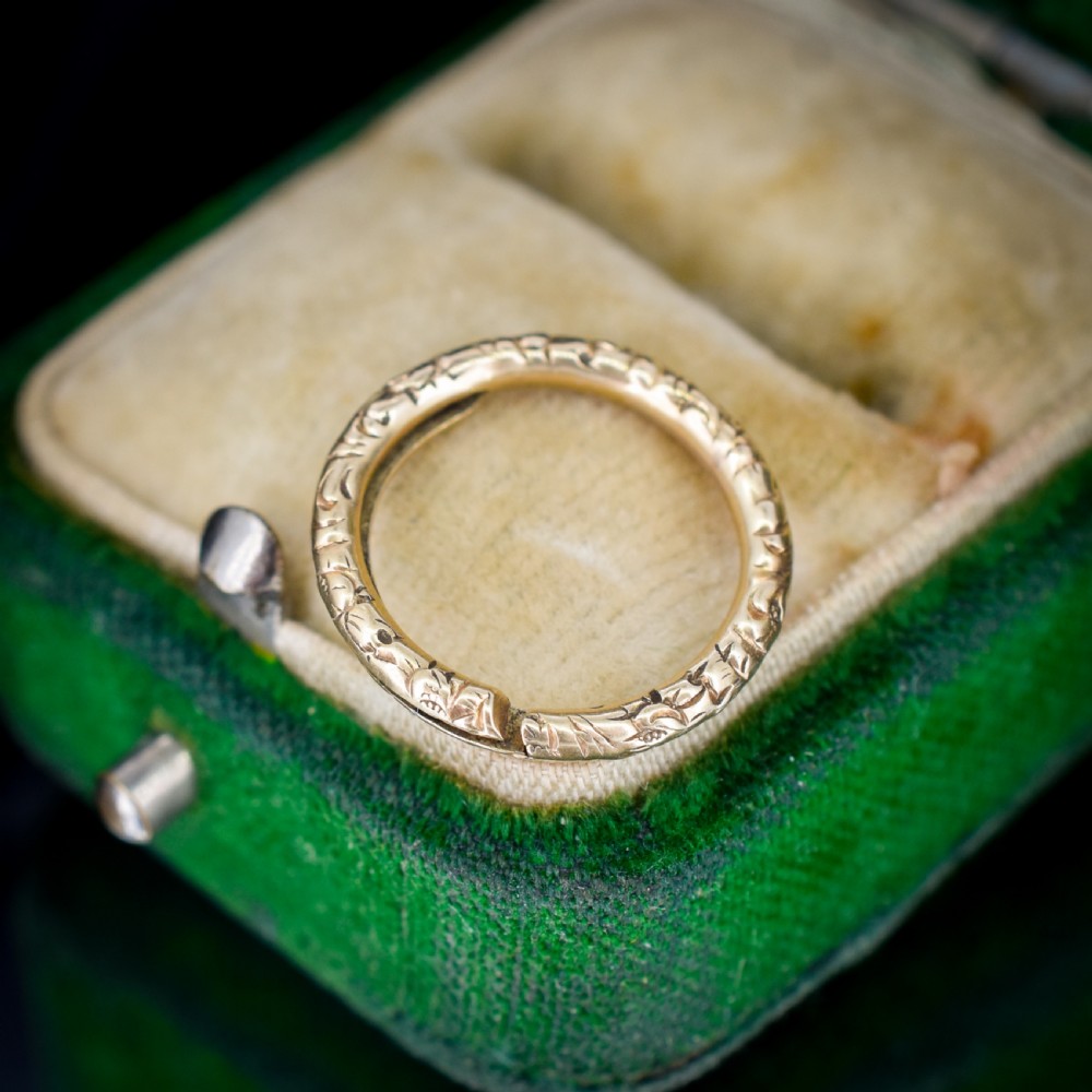 A small circular 12ct yellow gold split ring decorated with hand-engraved patterns along its outer edge. View IV
