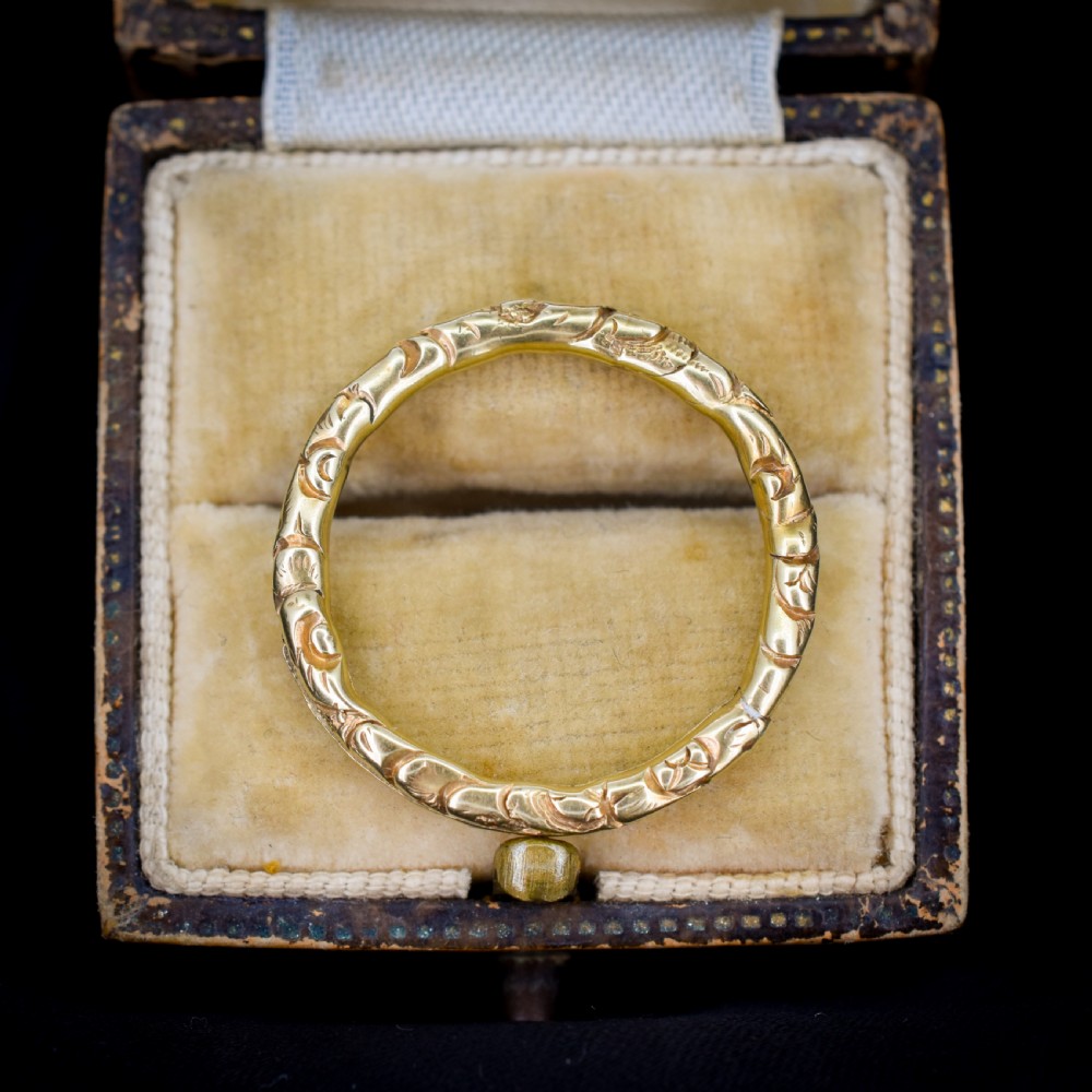 A circular Georgian 12ct yellow gold split ring featuring hand-engraved scrollwork around the outer edge.
