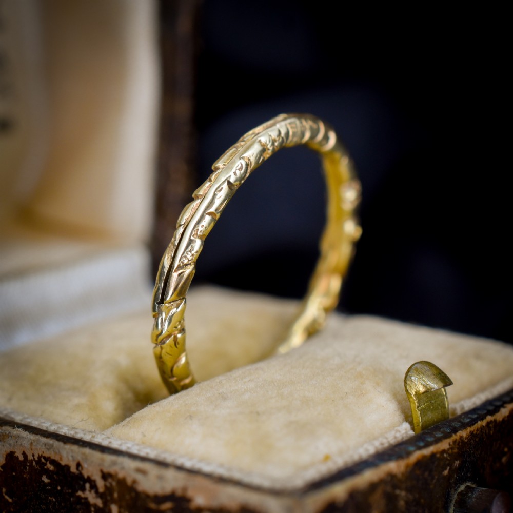 A circular Georgian 12ct yellow gold split ring featuring hand-engraved scrollwork around the outer edge. View VII