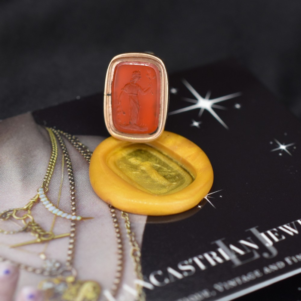 An antique gold fob pendant set with a rectangular orange carnelian gemstone carved with a classical standing figure holding a branch. View III
