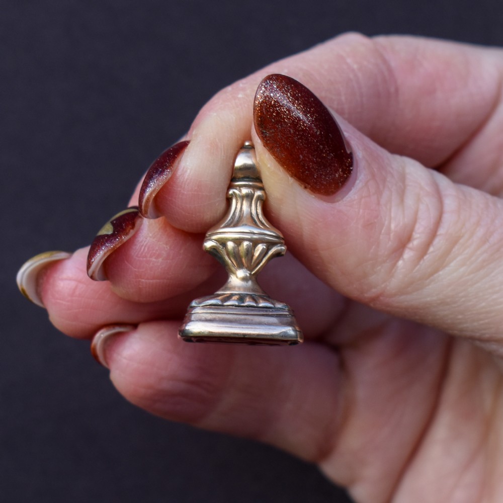 An antique gold fob pendant set with a rectangular orange carnelian gemstone carved with a classical standing figure holding a branch. View IX
