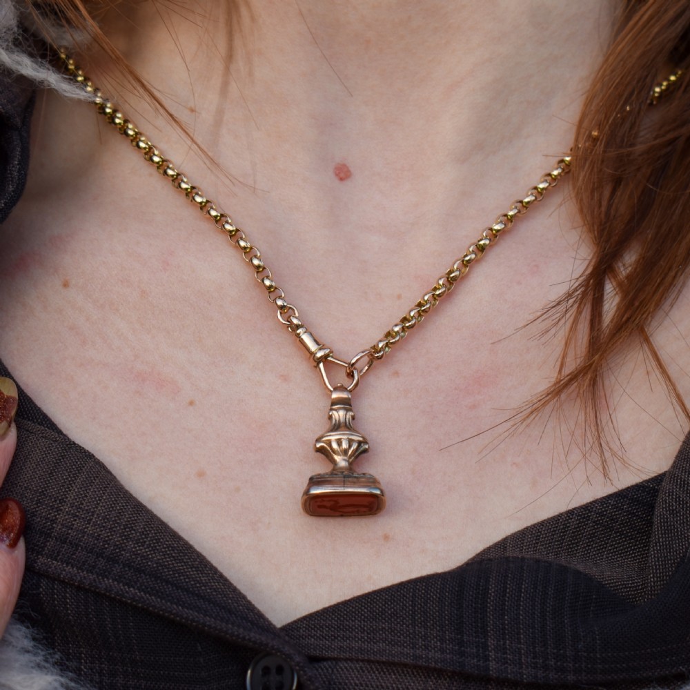 An antique gold fob pendant set with a rectangular orange carnelian gemstone carved with a classical standing figure holding a branch. View XI