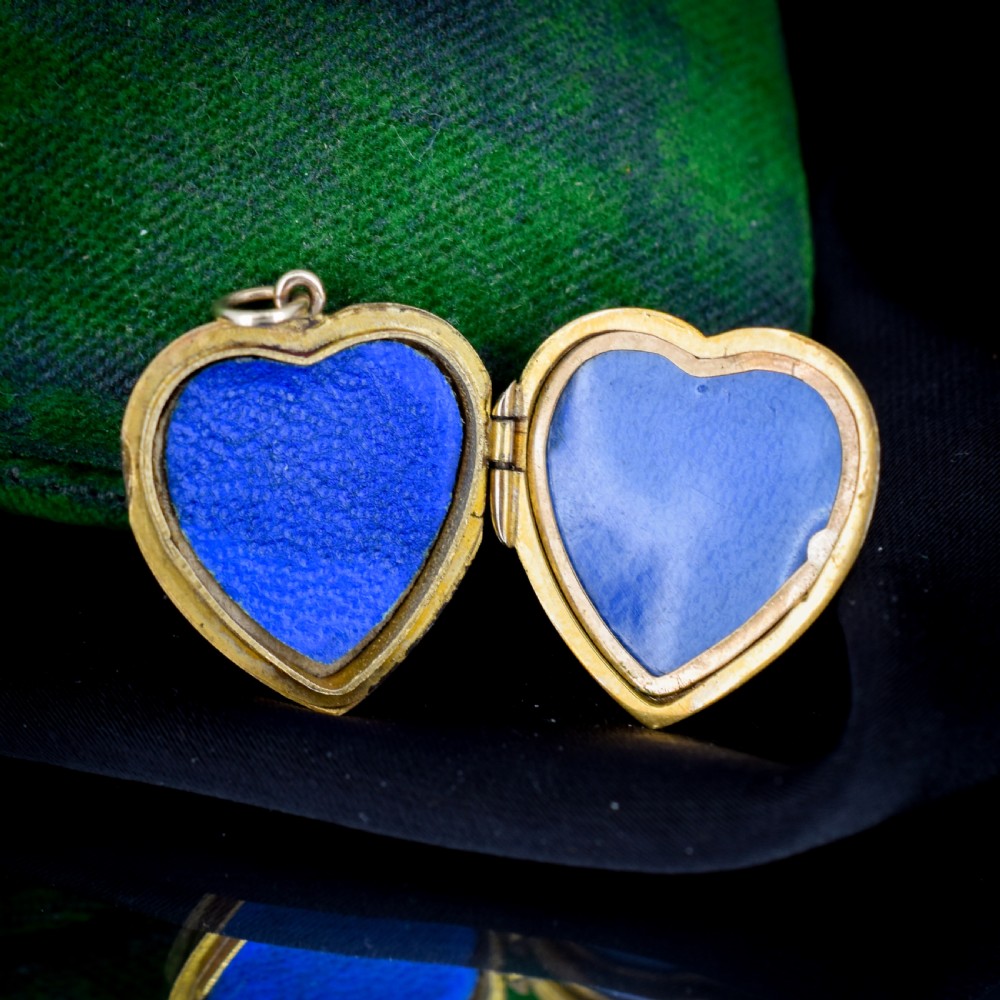 A vintage 9ct yellow gold heart-shaped locket pendant featuring engraved botanical scrollwork and a decorative scrolled border. View V
