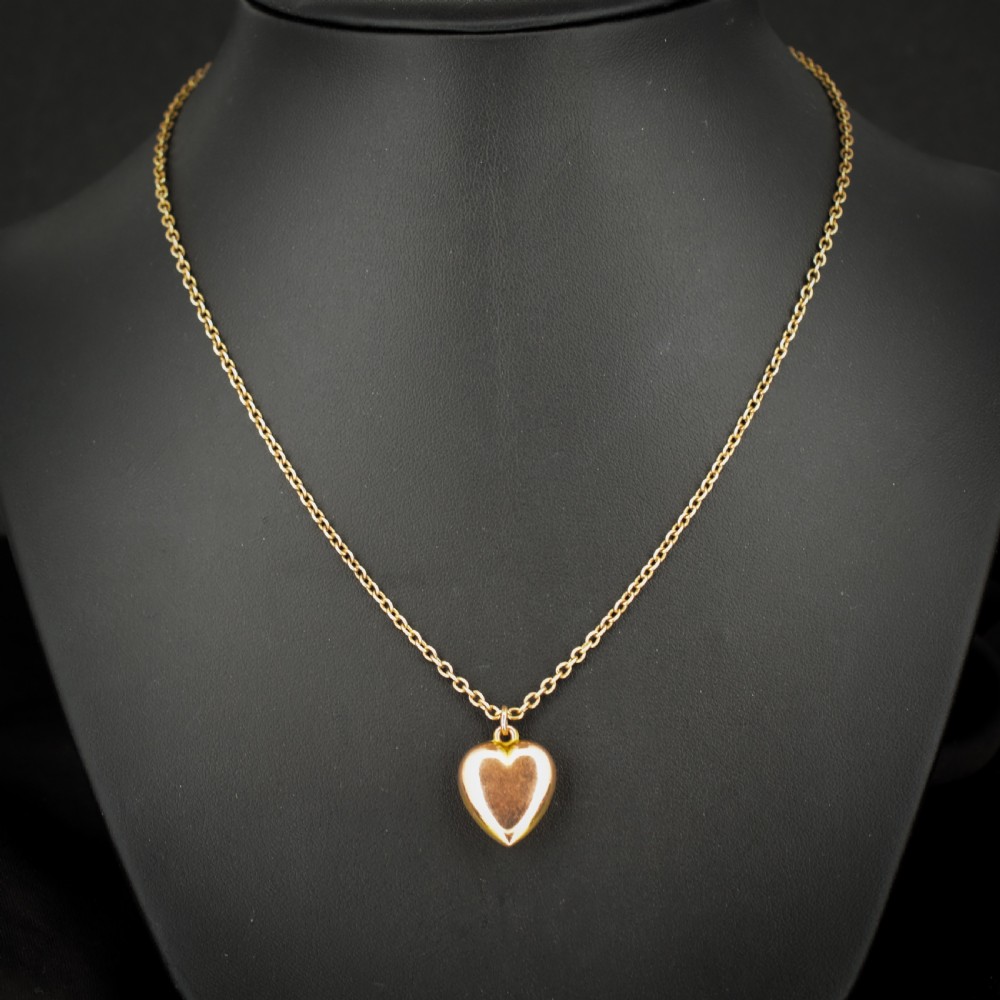 An antique 9ct yellow gold chain necklace with a smooth puffed heart pendant. View V