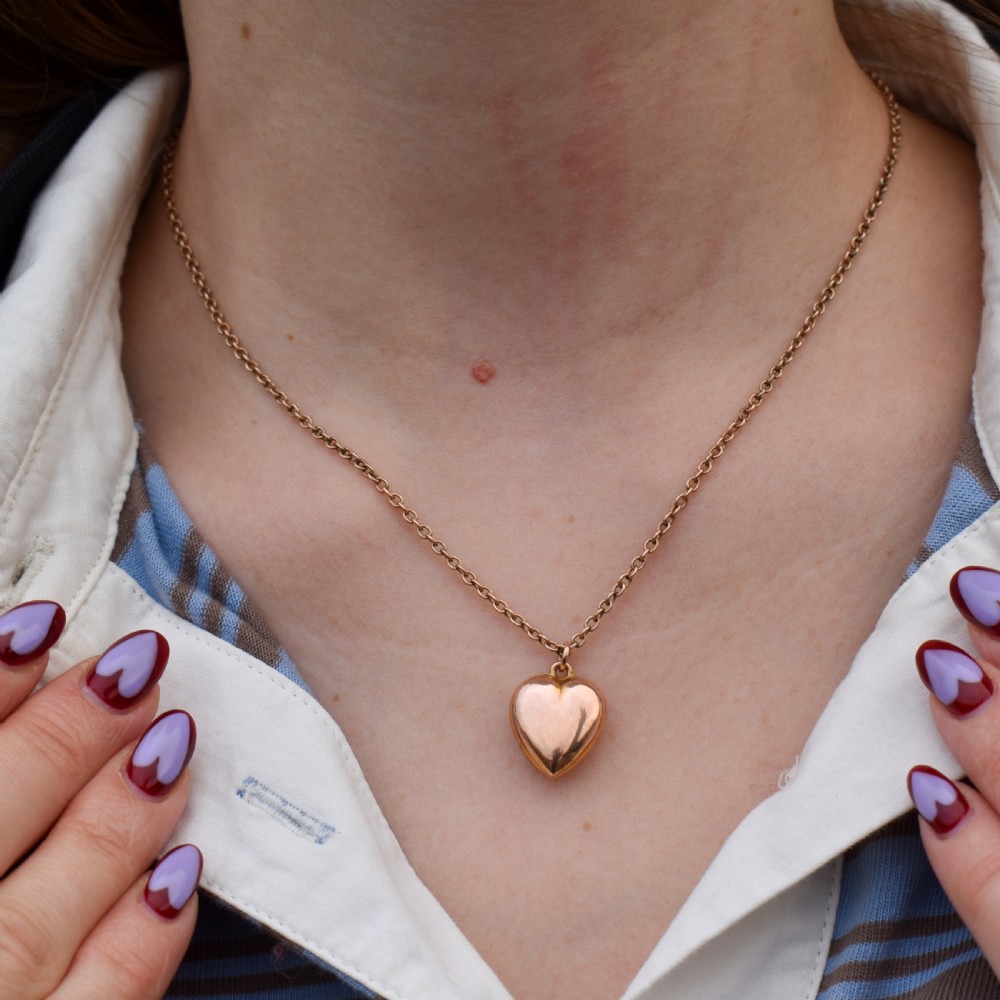 An antique 9ct yellow gold chain necklace with a smooth puffed heart pendant. View VI