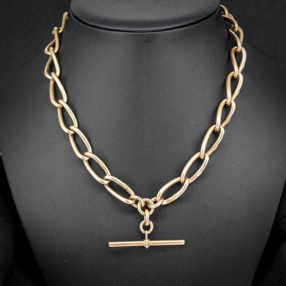 An antique 9ct yellow gold Albert watch chain necklace featuring polished oval links and a central suspended T-bar pendant.