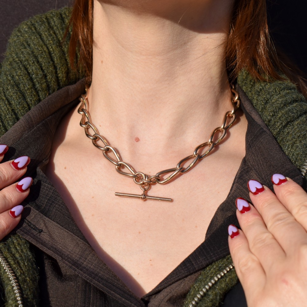 An antique 9ct yellow gold Albert watch chain necklace featuring polished oval links and a central suspended T-bar pendant. View V