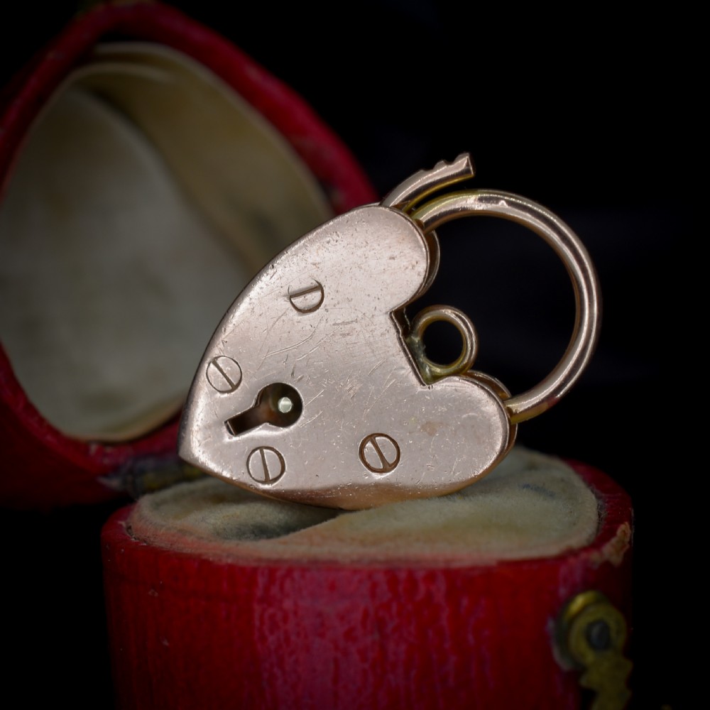 A 9ct rose gold heart-shaped padlock pendant featuring a hinged top shackle, central keyhole detail, and screw motif engravings. View II