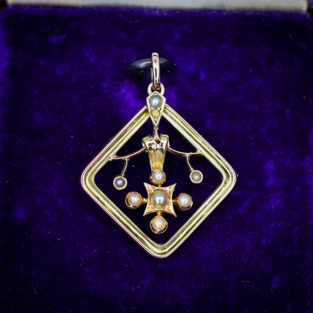 An antique 9ct yellow gold openwork lozenge-shaped pendant set with seed pearls.