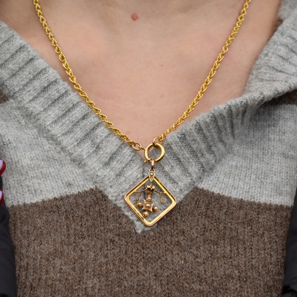 An antique 9ct yellow gold openwork lozenge-shaped pendant set with seed pearls. View V