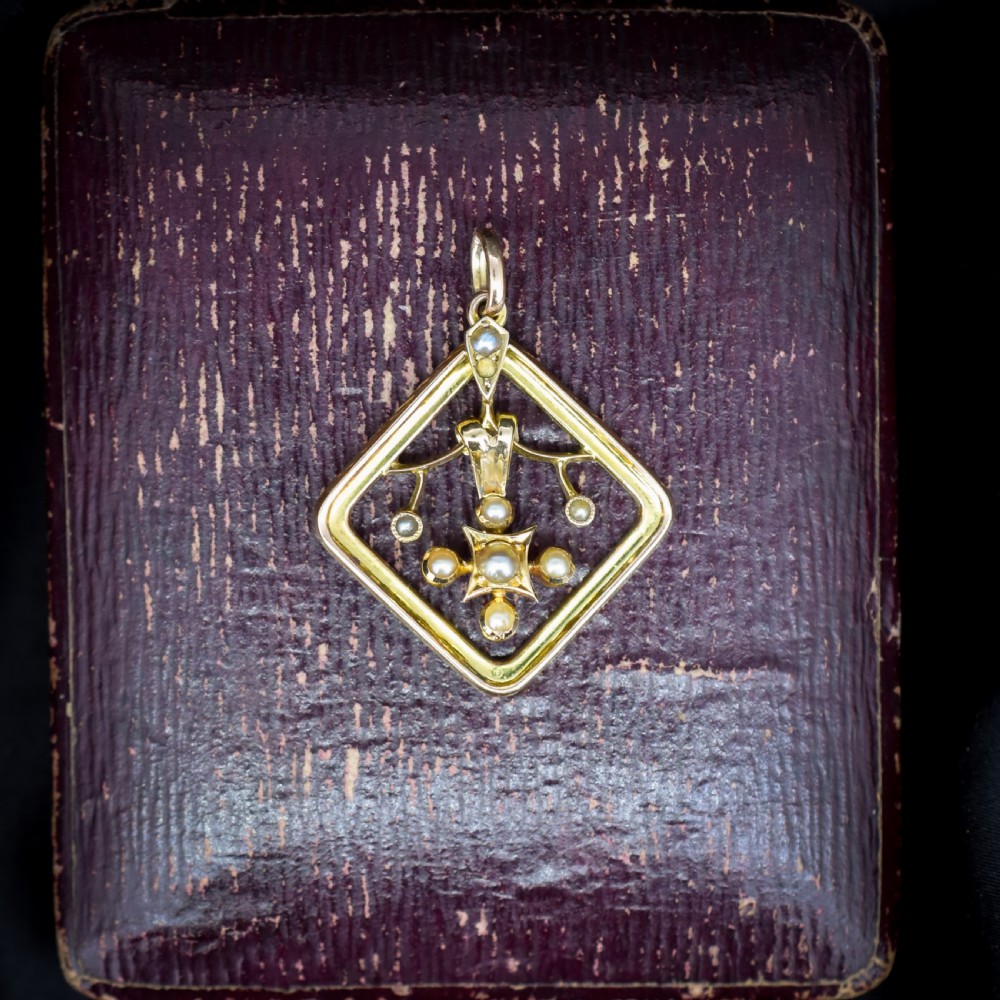 An antique 9ct yellow gold openwork lozenge-shaped pendant set with seed pearls. View X