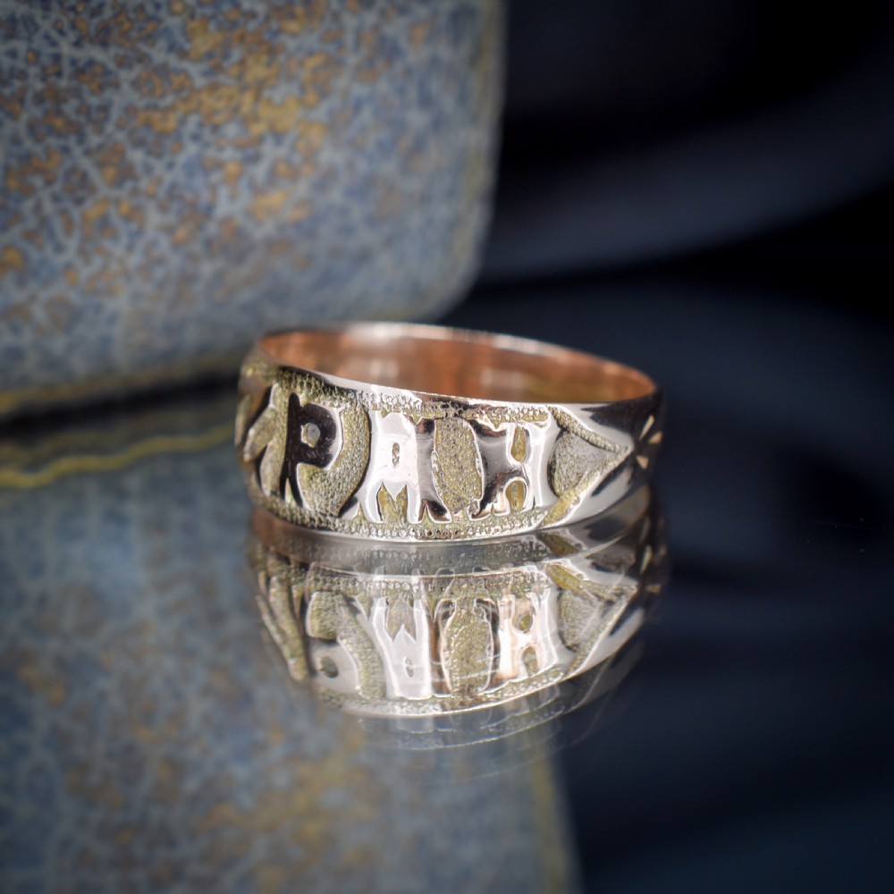 A wide 9ct gold band ring featuring the relief lettering MIZPAH set against a stippled textured background. View VI