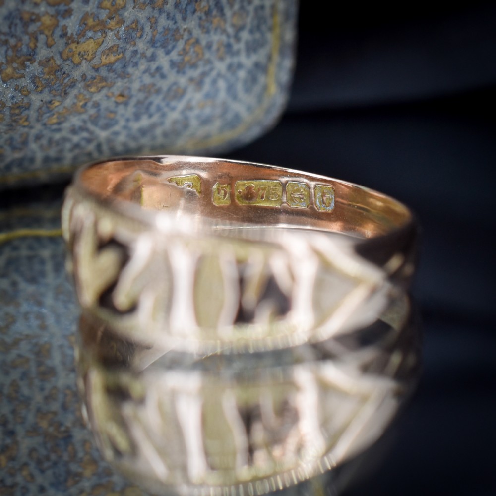 A wide 9ct gold band ring featuring the relief lettering MIZPAH set against a stippled textured background. View X