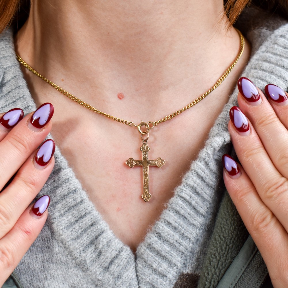 An Edwardian 9ct yellow gold cross pendant featuring hand-engraved foliate scrollwork, trefoil ends, and a circular top jump ring. View II