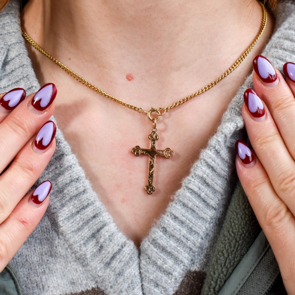 An Edwardian 9ct yellow gold cross pendant featuring hand-engraved foliate scrollwork, trefoil ends, and a circular top jump ring. View V
