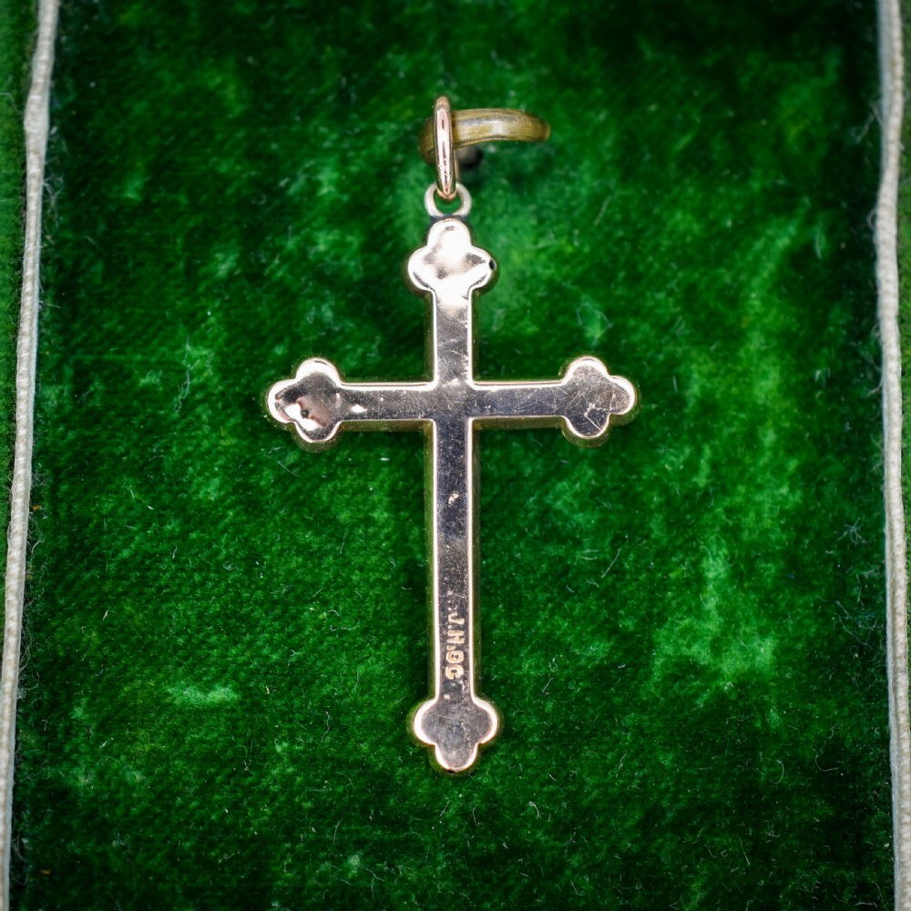 An Edwardian 9ct yellow gold cross pendant featuring hand-engraved foliate scrollwork, trefoil ends, and a circular top jump ring. View VI