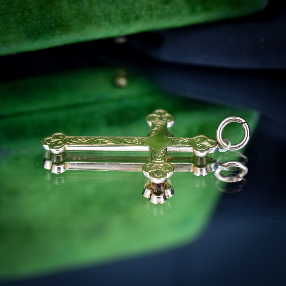 An Edwardian 9ct yellow gold cross pendant featuring hand-engraved foliate scrollwork, trefoil ends, and a circular top jump ring. View VIII