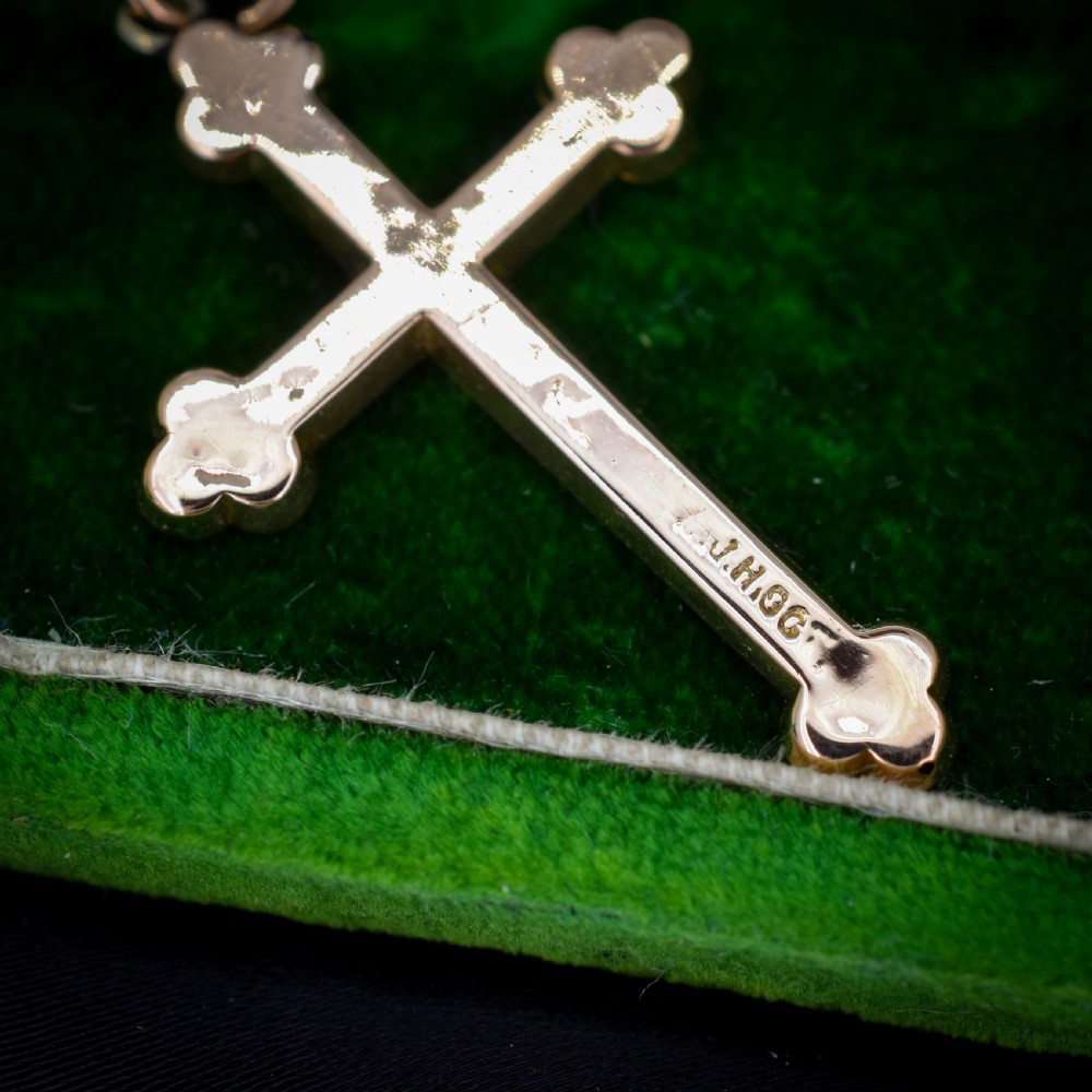 An Edwardian 9ct yellow gold cross pendant featuring hand-engraved foliate scrollwork, trefoil ends, and a circular top jump ring. View X