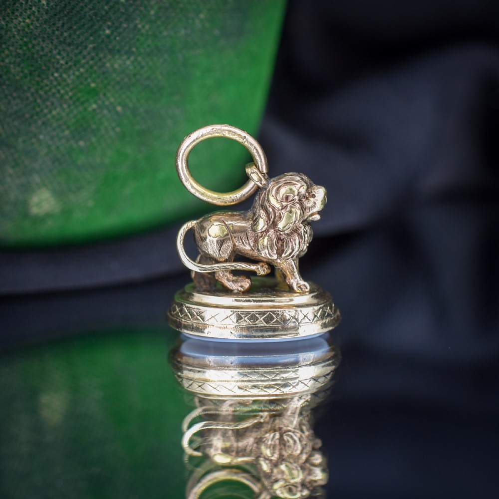 An antique gold fob seal featuring a three-dimensional standing lion figure on an engraved oval base set with a sardonyx stone. View XI