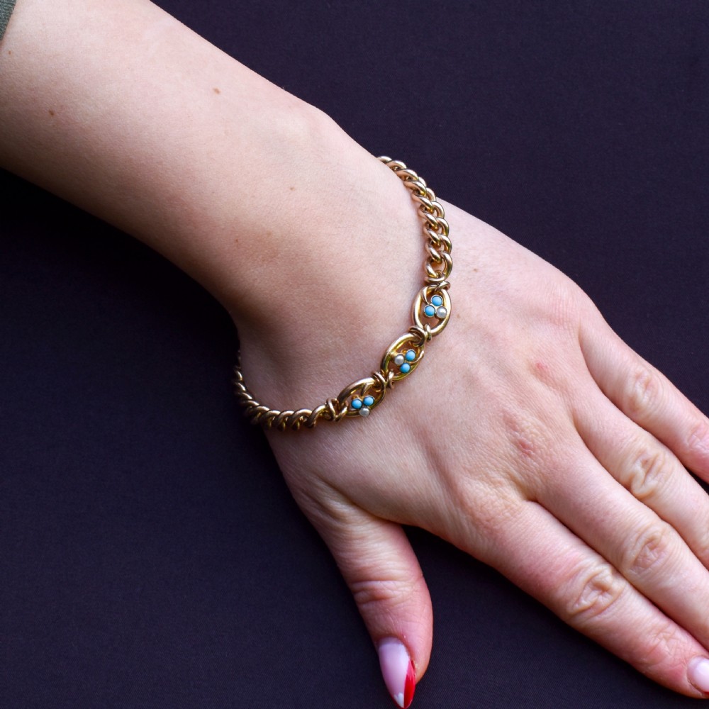 An antique rolled gold jewellery set featuring a curb link bracelet with turquoise and pearl embellishments alongside a matching bar brooch. View III