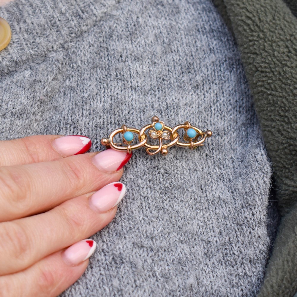 An antique rolled gold jewellery set featuring a curb link bracelet with turquoise and pearl embellishments alongside a matching bar brooch. View V