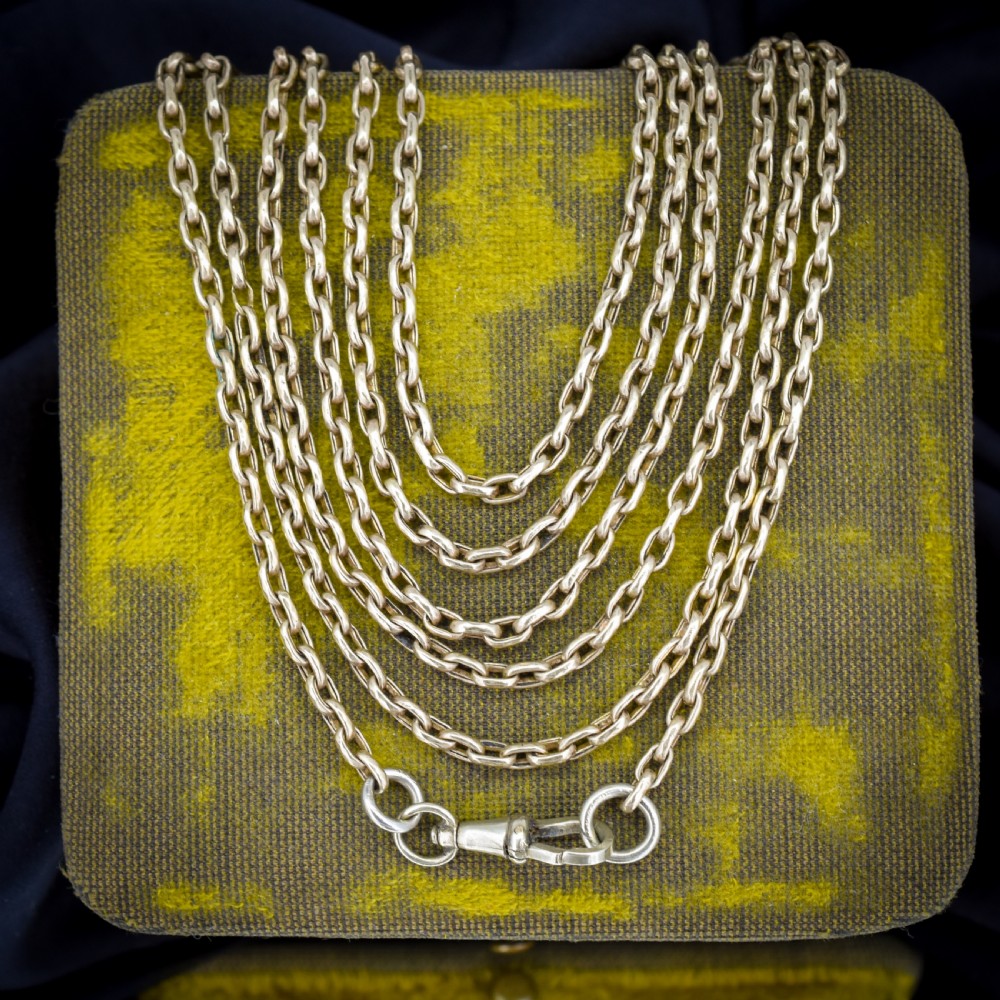 An antique rolled gold long chain with faceted belcher links arranged in loops and secured with a swivel dog clip. View IV