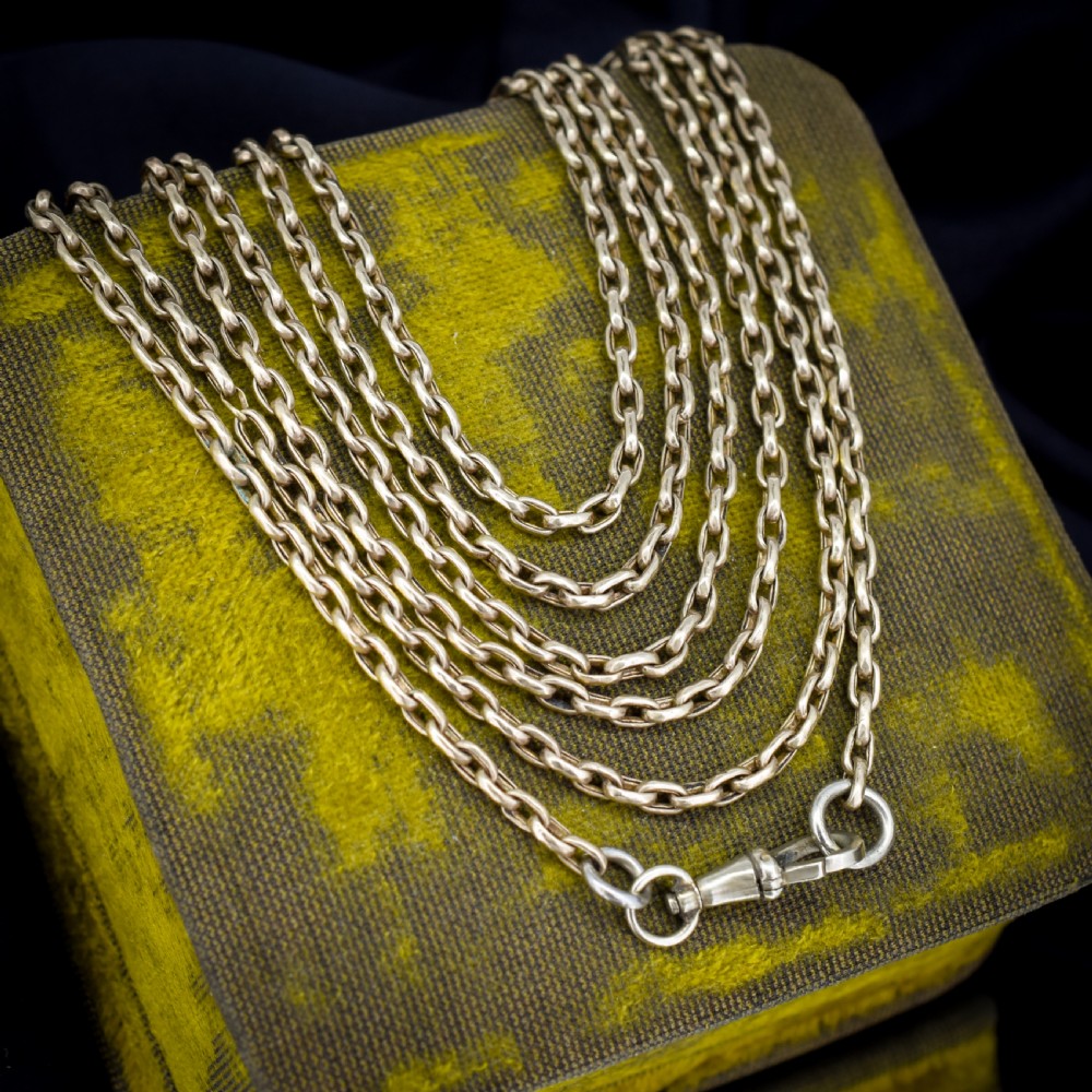 An antique rolled gold long chain with faceted belcher links arranged in loops and secured with a swivel dog clip. View V