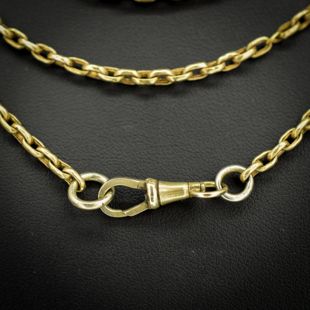 An antique rolled gold long chain with faceted belcher links arranged in loops and secured with a swivel dog clip. View VI