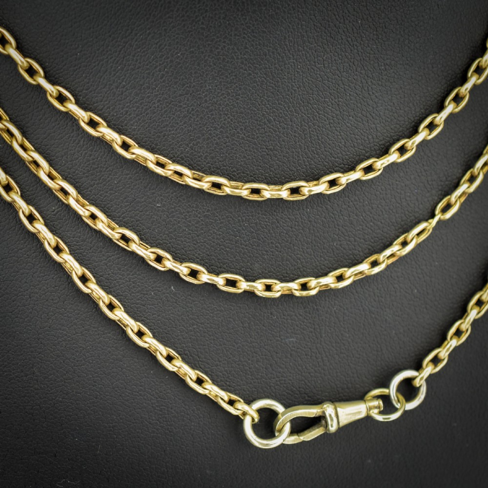 An antique rolled gold long chain with faceted belcher links arranged in loops and secured with a swivel dog clip. View VII